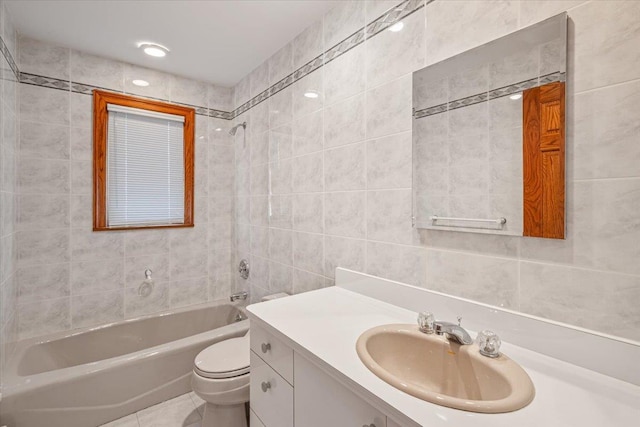 full bathroom featuring vanity, bathtub / shower combination, tile patterned flooring, tile walls, and toilet