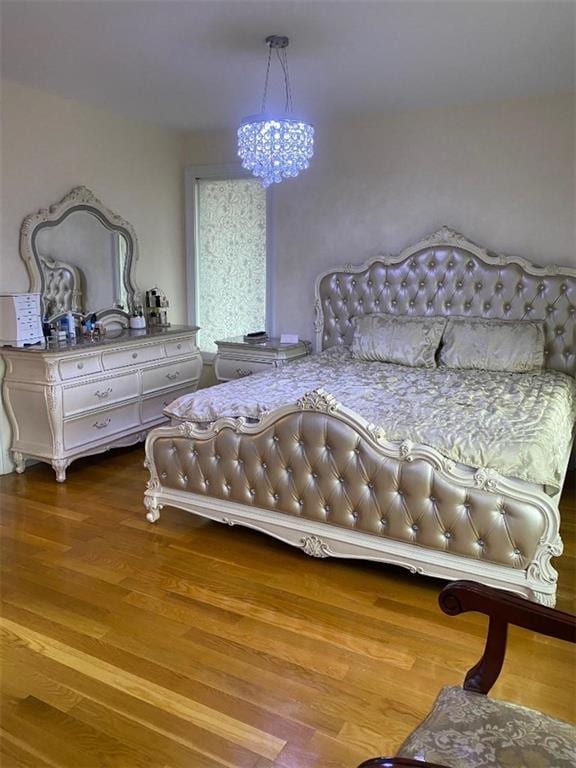 bedroom featuring a chandelier and wood finished floors