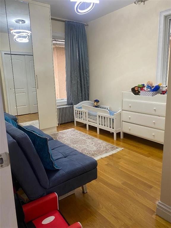 bedroom with radiator and wood finished floors