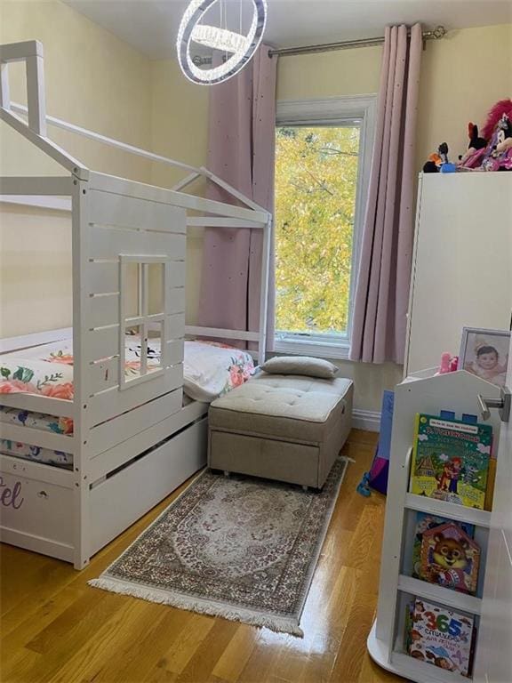 bedroom with wood finished floors and a chandelier