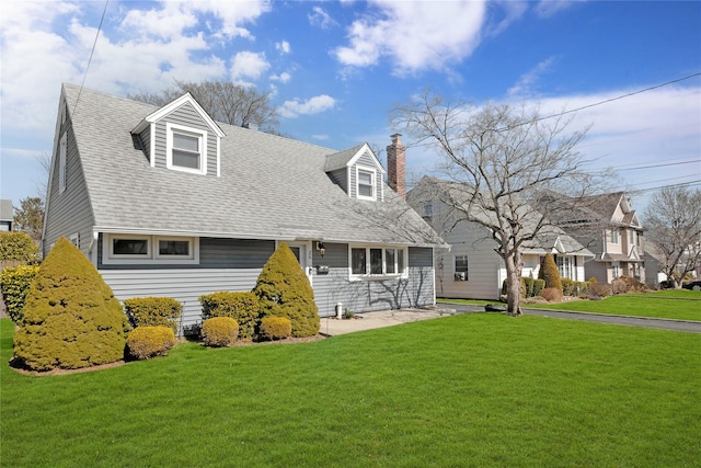 cape cod home featuring a front yard, roof with shingles, and a chimney