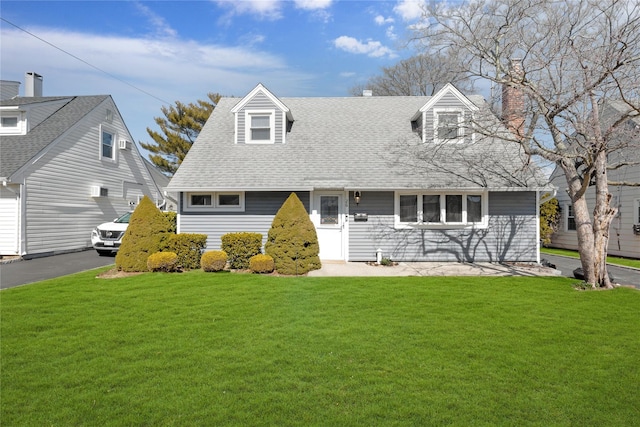 cape cod house featuring a front lawn, a chimney, aphalt driveway, and a shingled roof