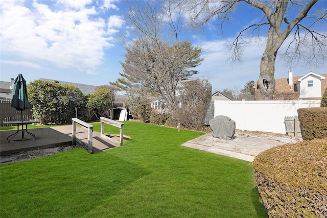 view of yard with a patio area, a storage unit, an outdoor structure, and fence