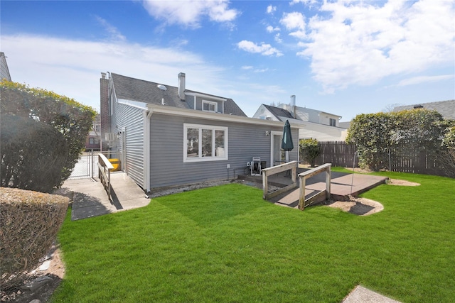 back of property with a patio, fence, a lawn, and a chimney