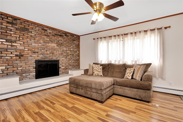 living area featuring a wealth of natural light, a baseboard radiator, and light wood finished floors