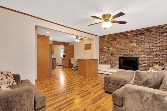 living room with ceiling fan, ornamental molding, light wood-style flooring, a fireplace, and a baseboard radiator