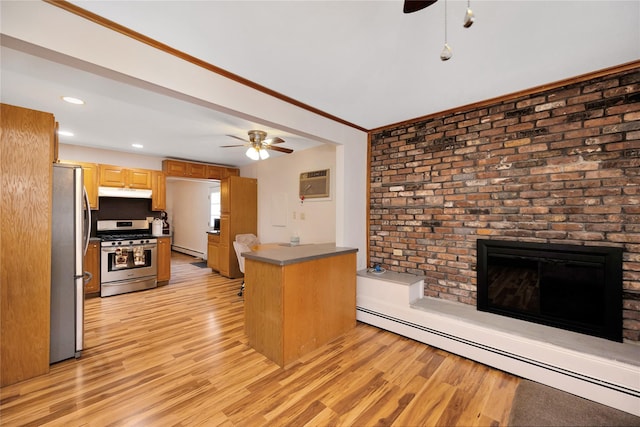 kitchen featuring baseboard heating, appliances with stainless steel finishes, a ceiling fan, and light wood finished floors