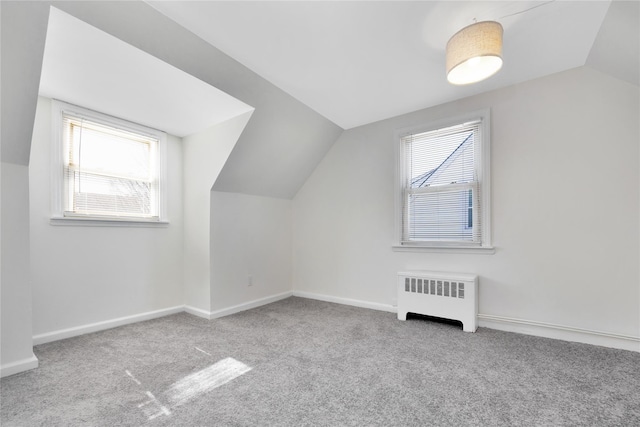 bonus room with vaulted ceiling, radiator heating unit, carpet, and baseboards