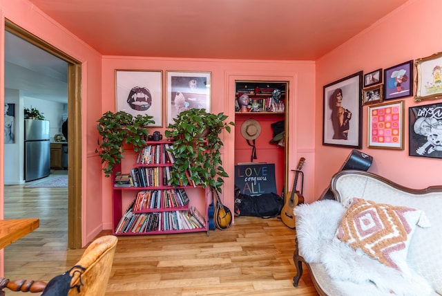 sitting room with crown molding and wood finished floors