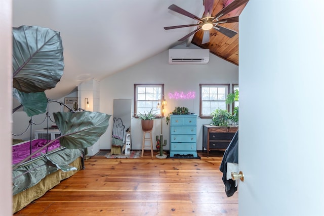 bedroom featuring hardwood / wood-style floors, an AC wall unit, a ceiling fan, and lofted ceiling