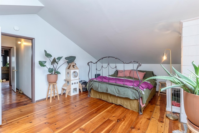 bedroom with lofted ceiling and light wood-style flooring