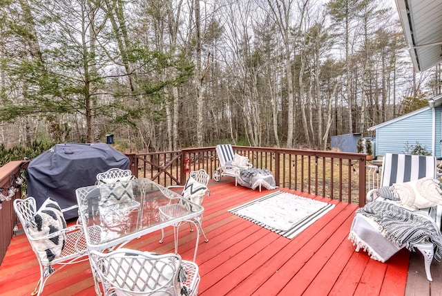 deck with a grill and outdoor dining area