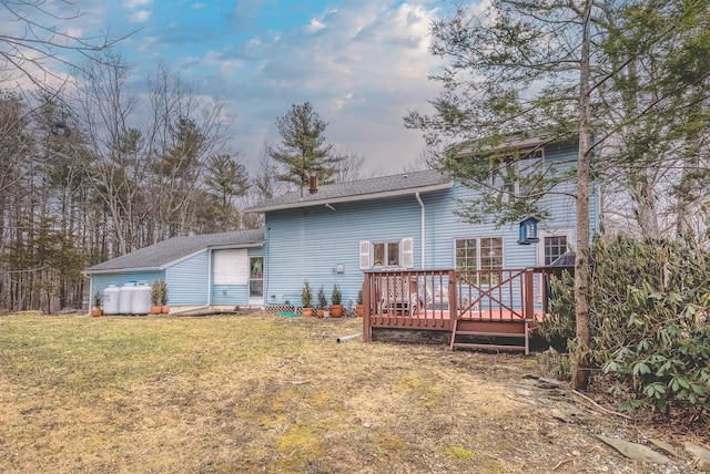 back of property featuring a wooden deck and a lawn