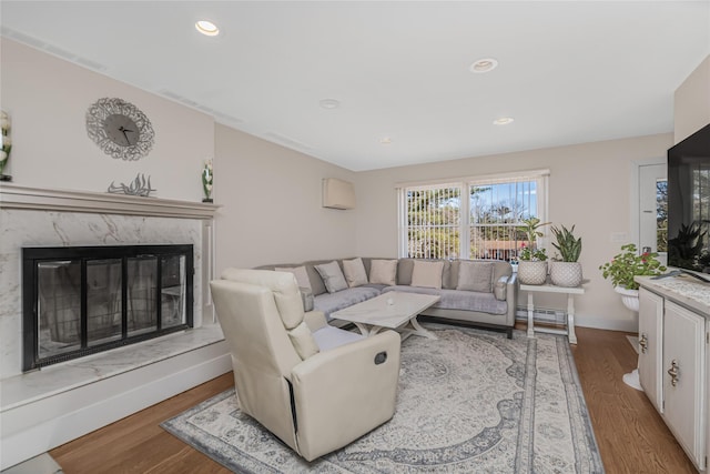 living area featuring a high end fireplace, recessed lighting, and wood finished floors