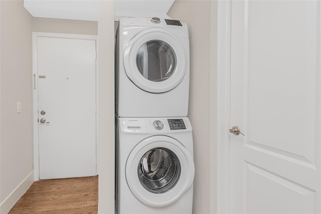 38 Marjorie Dr, Monticello, NY 12701 - laundry room featuring laundry area, stacked washer and clothes dryer, baseboards, and wood finished floors