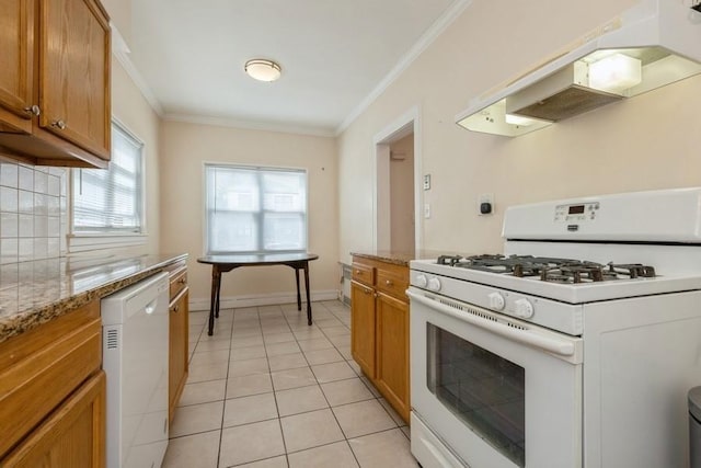 kitchen featuring under cabinet range hood, ornamental molding, light tile patterned floors, brown cabinets, and white appliances