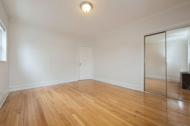 unfurnished bedroom with baseboards, hardwood / wood-style floors, and crown molding