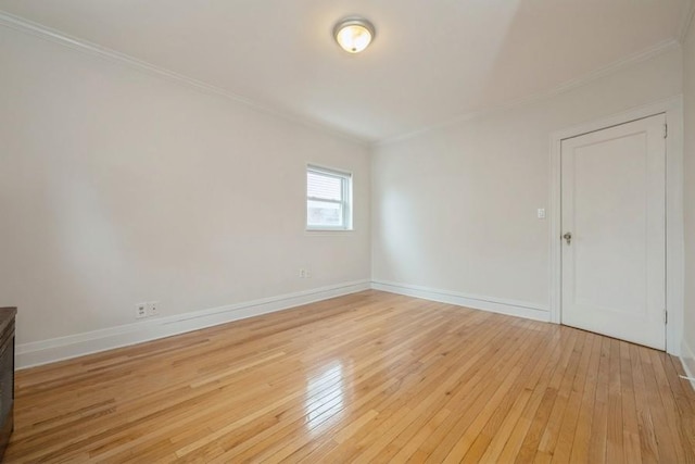 unfurnished room featuring light wood-type flooring, baseboards, and ornamental molding