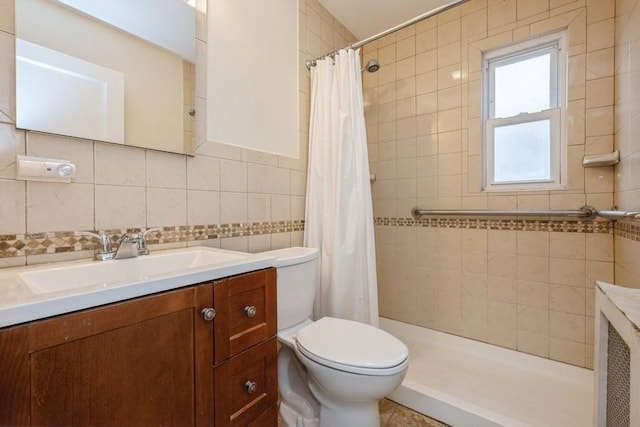 full bath with a tile shower, toilet, tile walls, and vanity