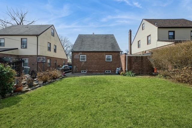 back of house featuring a lawn, brick siding, and a wall mounted air conditioner