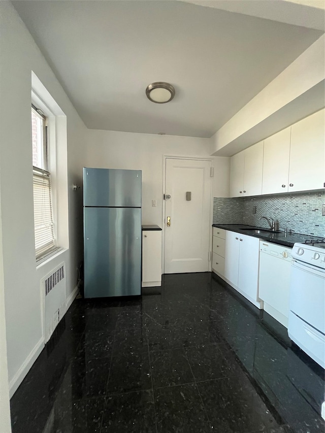 kitchen with white appliances, radiator heating unit, a sink, dark countertops, and backsplash