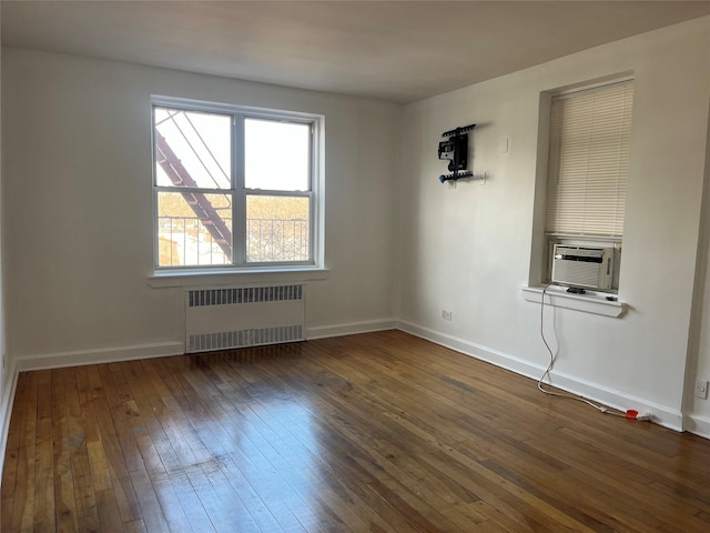 unfurnished room featuring dark wood-type flooring, radiator heating unit, cooling unit, and baseboards