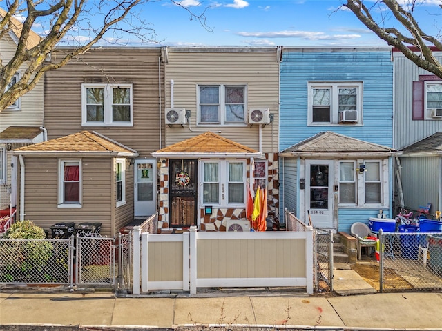 multi unit property featuring ac unit, a gate, and a fenced front yard