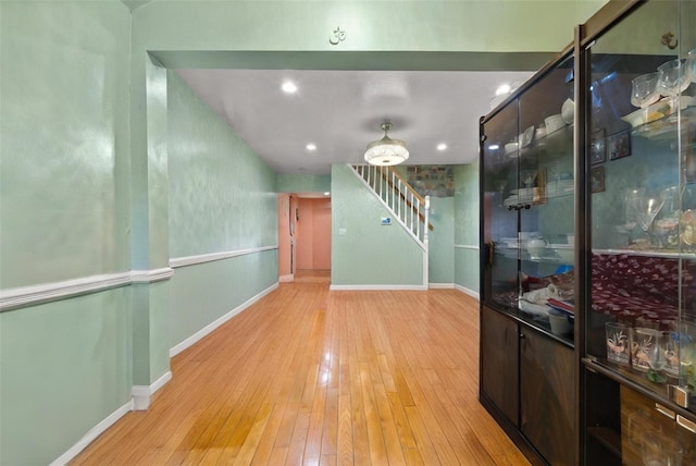 corridor featuring stairs, recessed lighting, baseboards, and wood-type flooring