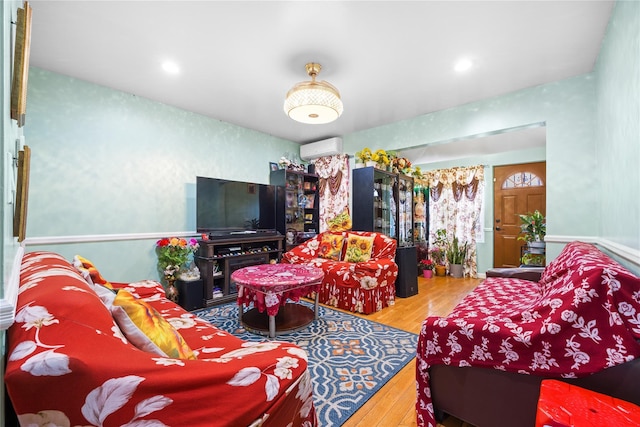 living room with hardwood / wood-style floors, a wall unit AC, and recessed lighting