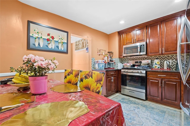 kitchen with dark countertops, recessed lighting, backsplash, and appliances with stainless steel finishes