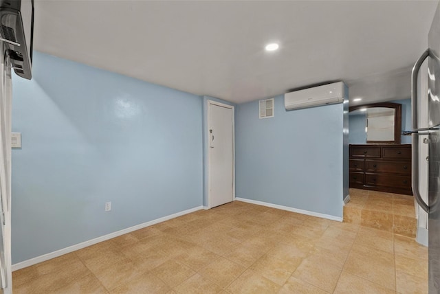 spare room with visible vents, recessed lighting, a wall mounted AC, and baseboards