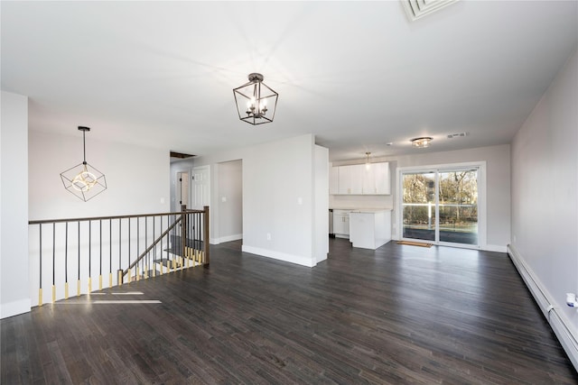 unfurnished living room featuring a baseboard heating unit, an inviting chandelier, dark wood-style floors, and visible vents