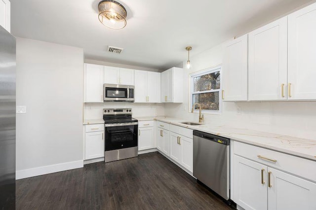 kitchen with decorative backsplash, appliances with stainless steel finishes, light stone countertops, and a sink