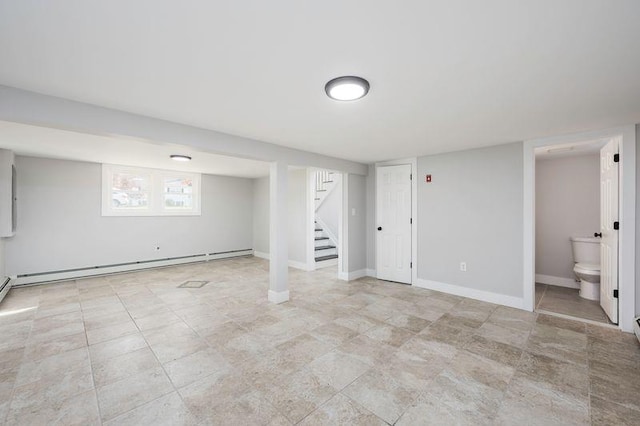 basement featuring stairway, baseboards, and a baseboard heating unit