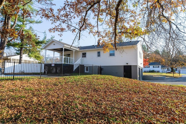 back of house featuring a lawn and fence