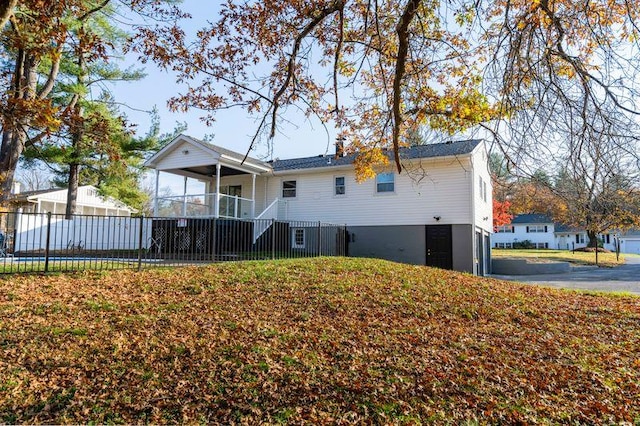 back of property with a yard and fence