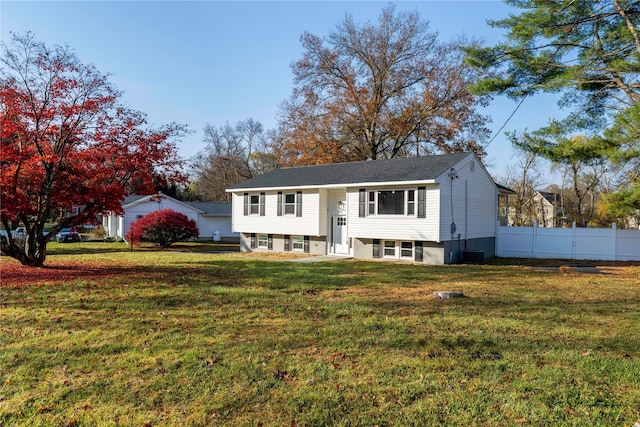 bi-level home with central air condition unit, a front yard, and fence