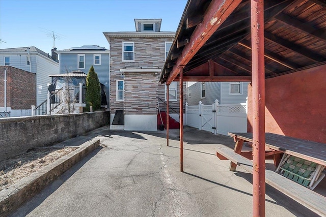 view of patio featuring fence, a carport, and a gate