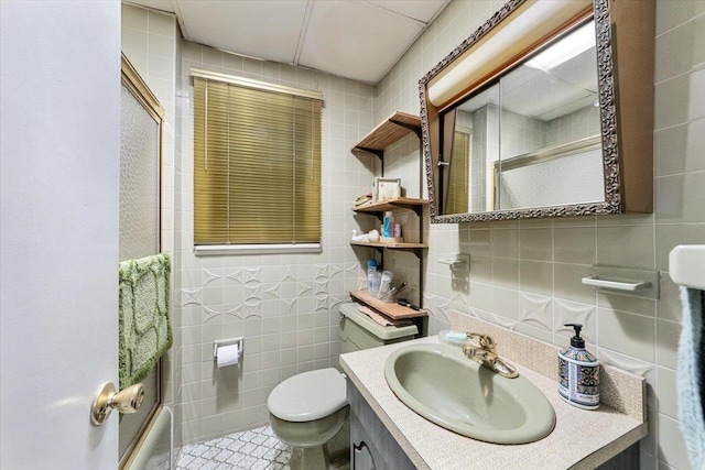 full bath with a shower, toilet, tile walls, and vanity