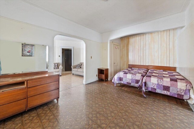 bedroom with tile patterned floors and arched walkways