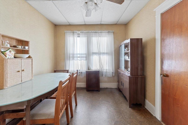 dining space with tile patterned floors, a ceiling fan, and baseboards