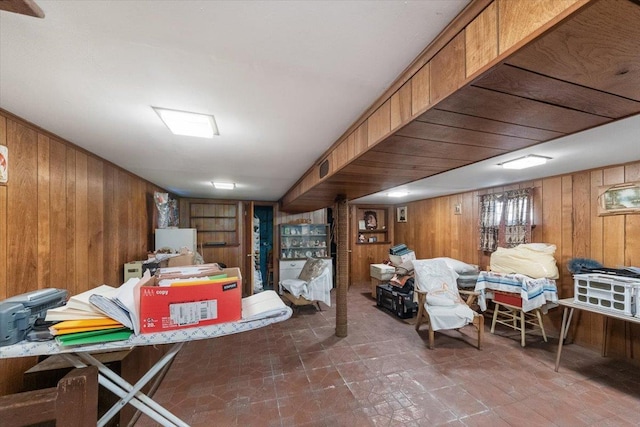 finished basement featuring visible vents and wood walls