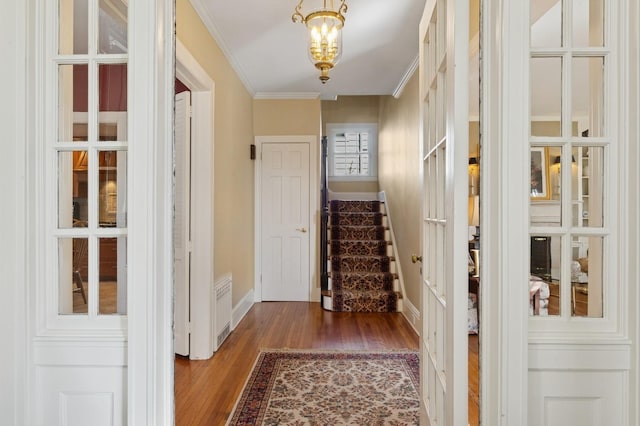 entryway with baseboards, stairs, ornamental molding, an inviting chandelier, and wood finished floors