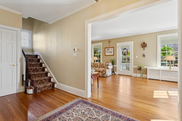 entrance foyer featuring stairway, wood finished floors, baseboards, and ornamental molding