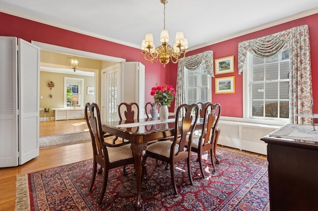 dining room with crown molding, wood finished floors, and a chandelier