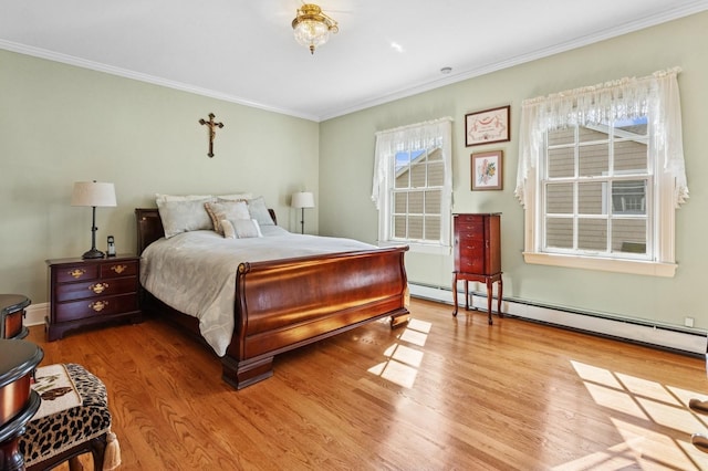 bedroom featuring a baseboard heating unit, wood finished floors, and ornamental molding