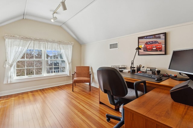 office featuring baseboards, visible vents, vaulted ceiling, hardwood / wood-style flooring, and track lighting