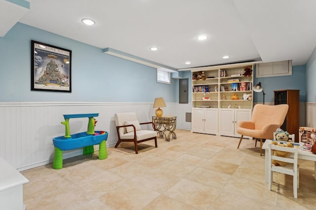 sitting room with electric panel, recessed lighting, and wainscoting