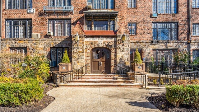 doorway to property featuring brick siding and stone siding