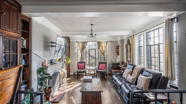 interior space with dark wood finished floors, a notable chandelier, ornamental molding, and a fireplace